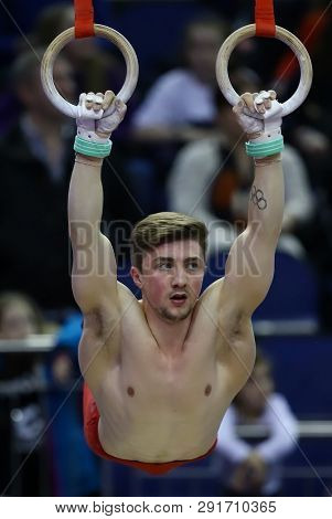 LONDON, ENGLAND - MARCH 23 2019: Sam Oldham of Great Britain performs on the rings during the Superstars if Gymnastics at The O2 Arena, London, United Kingdom.