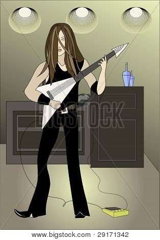 En langhåret ung mand spiller guitar på scenen