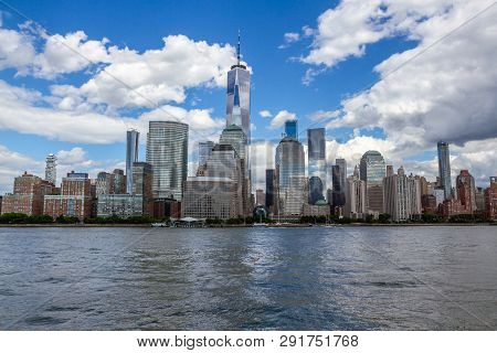 Manhattan Skyline In New York City As Seen From The Harbor. White Clouds In Blue Sky, Freedom Tower 