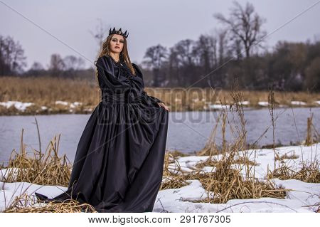 Mysterious Lady With Long Hair In Black Raincoat Posing In Forest Outdoors.horizontal Image Orientat
