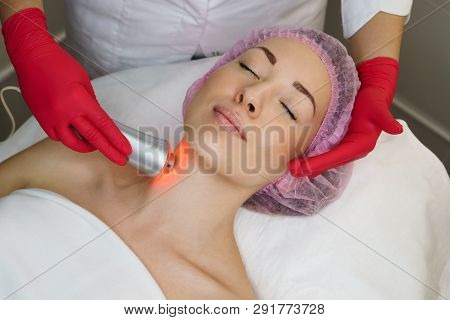 Ultrasound Chromotherapy. Hardware Cosmetology. Beautician Carries Out Procedure For Tightening Skin