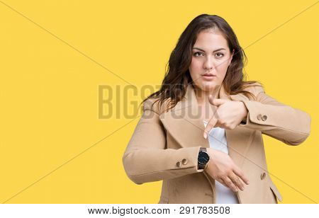 Beautiful plus size young woman wearing winter coat over isolated background In hurry pointing to watch time, impatience, upset and angry for deadline delay