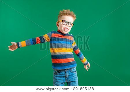 Gamine Boy In Glasses On A Green Background In The Studio. Close-up