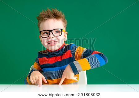 The Gamine Boy In Glasses Shows Tongue. Close-up.