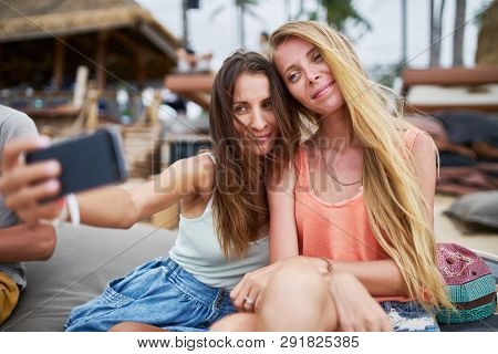 two female russian tourists taking selfie at beachside resort on koh samui island in thailand
