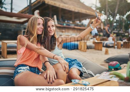 two female russian tourists taking selfie at beachside resort on koh samui island in thailand