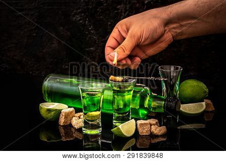 Absinthe In Glass With Lime Slices And Sugar Cubes. Absinthe Poured Into A Glass. Space For Text.