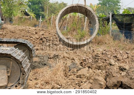 Excavator Backhoe Raising Pipe At Construction Site