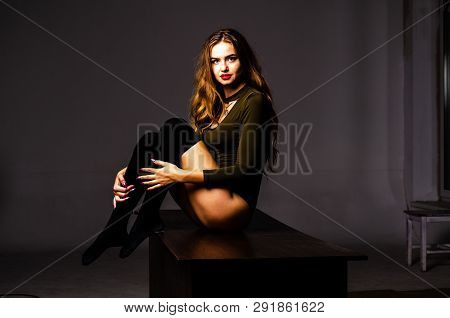 Beautiful Dancer. Girl Model. The Girl Sits In A Hat And Sits On A Table. Girl In A Beautiful Underw