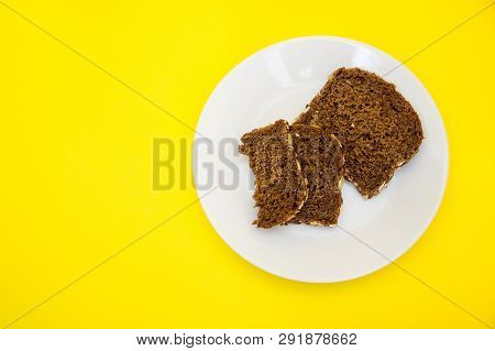 Sliced Rye Bread On The White Plare And Yelow Background. Whole Grain Rye Bread With Seeds
