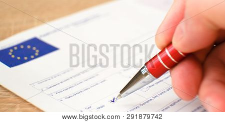 Schengen Visa, Questionnaire. Hand With Pen Completing A Questionary