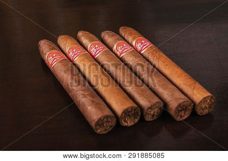 Five Partagas Cuban Cigars With Red Label On A Table