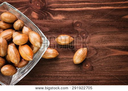 Pecan Nuts In The Shell In Glass Bowl On Wooden Background