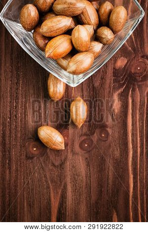 Pecan Nuts In The Shell In Glass Bowl On Wooden Background