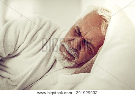 Close-up Portrait Of An Elderly Bearded Wrinkled Man Experiencing Pain