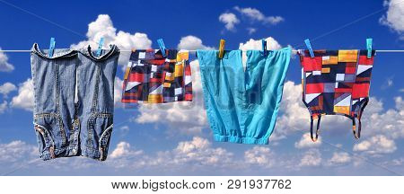 The Washed Clothes Are Dried On A Clothesline, Against The Blue Sky