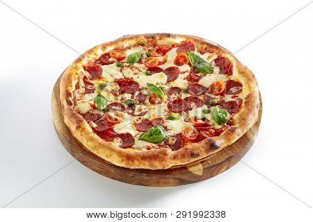 Pepperoni or Diabola Pizza with Salami, Chili Pepper, Mozzarella Cheese, Fresh Basil, Cherry Tomatoes, Tomato Sauce Isolated on White Background. Traditional Italian Flatbread on Wood Plate Close Up
