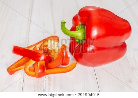 Group Of One Whole Four Slices Of Bulgarian Red Bell Pepper On White Wood