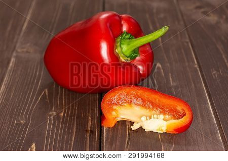 Group Of One Whole One Slice Of Bulgarian Red Bell Pepper On Brown Wood