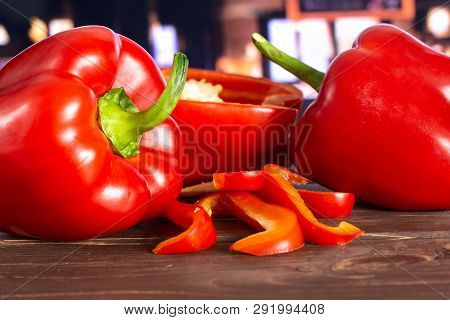 Group Of Two Whole One Half Four Slices Of Bulgarian Red Bell Pepper With Restaurant In Background