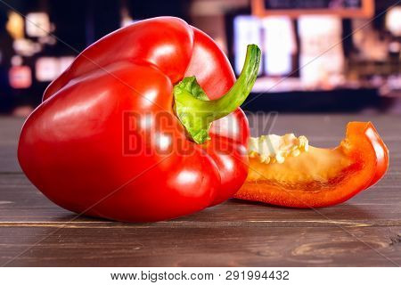 Group Of One Whole One Slice Of Bulgarian Red Bell Pepper With Restaurant In Background