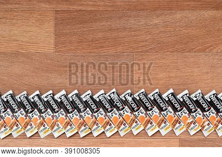 Many Nescafe Caramel Cream Coffee Sticks On Wooden Background. Nescafe Is A Brand Of Coffee Made By 
