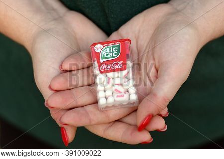 Young Girl Holds Tic-tac Hard Mints Pack With Coca-cola Taste. Tic Tac Is A Brand Of Small Hard Mint