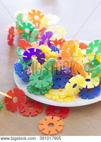 Plastic Flakes Blocks On Plate. Instructive Toy That Promotes Spatial Hhinking And Fine Motor Skills