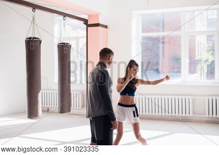 In A Spacious Loft, A Male Trainer And His Female Mentee Conduct A Boxing Training Session