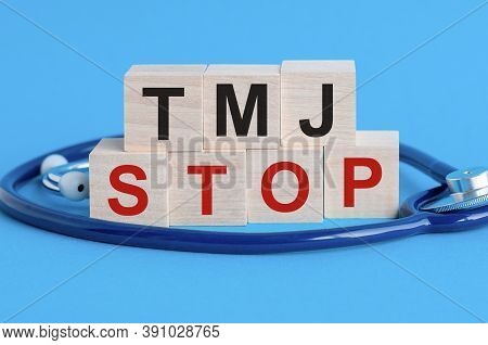 Wooden Block With Words Tmj Stop - With Stethoscope On The Table, Insurance And Medical Concept, Blu
