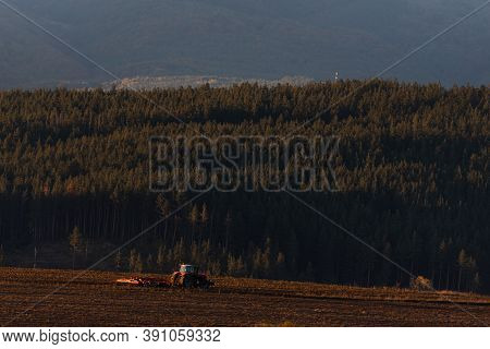 Tractor Moving Hay Field On Dark Wood And Mountain Background Forest Scenery Bulgaria Rural Copy Spa