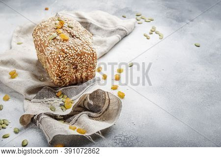 Whole Wheat Organic Rye Dark Bread With Pumpkin Seeds, Dried Fruit, Raisins And Sesame Seeds On Gray