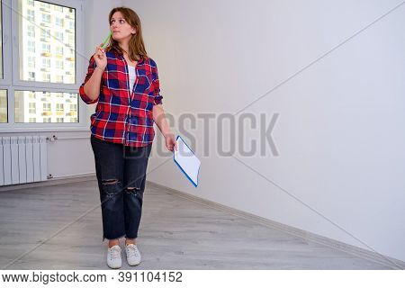 Inspection In A Plaid Shirt Of The Apartment In The New House For Purchase Or Identification Of Defe