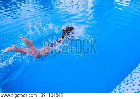 A Woman Jumps Into The Pool, Entering The Water And Splashin, One, G