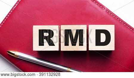 Rmd Is Made Up Of Wooden Cubes That Stand On A Burgundy Notebook Near The Pen. Business Concept