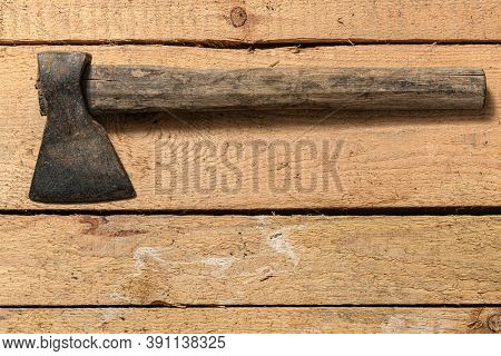 Old vintage axe closeup on a wooden background, household hand tools