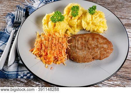 Homemade Minced Meat Cutlet Served With Mashed Potatoes And Carrot Salad.