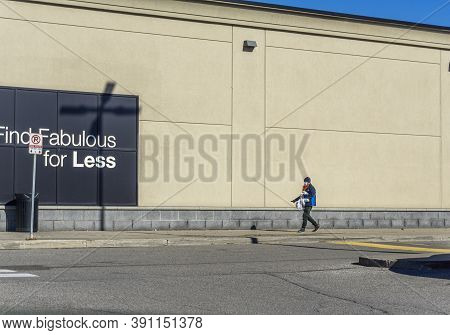 Scarborough, Canada, October 2020 - Man Alone Wearing Face Mask And Holding Shopping Bags Walks By T