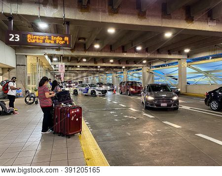 People Waiting To Be Picked Up At The Arrivals Area Of The Orlando International Airport