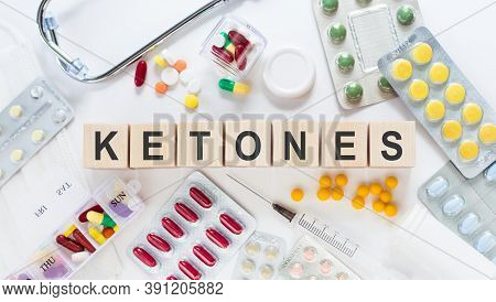 Ketones Medicine Word On Wooden Blocks On A Desk. Medical Concept With Pills, Vitamins, Stethoscope 