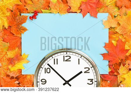 Plain Wall Clock In The Center Of Autumn Orange Red Leaves And Fall Foliage. Two Oclock. Copy Space,