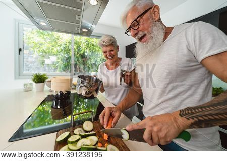 Happy Senior Couple Having Fun Cooking Together At Home - Elderly People Preparing Health Lunch In M