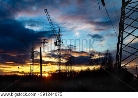 High Cranes Build The House In The Evening. Sunset. Russia. Background.