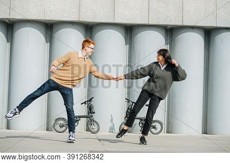 Smiling Couple Having Fun, Standing On One Foot, Pulling One Another.