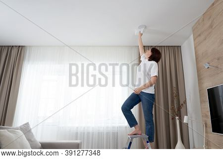 Woman Cleaning Ceiling With A Mop. Housewife Cleaning Living Room