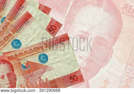 50 Philippine Piso Bills Lies In Stack On Background Of Big Semi-transparent Banknote. Abstract Busi