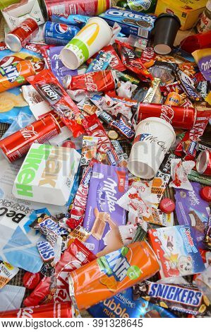 Many Wrappings And Cans From Used Products By Famous Worldwide Brands. Pattern Of Trash Of Various C