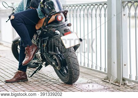 Cropped Image Confident Man In Leather Boots An Ripped Jeans Leaning On Motorcycle