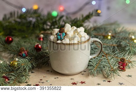 A Gingerman In A Mug With Hot Cocoa And Marshmallow. Christmas Holiday Decorations And Blurred Xmas 