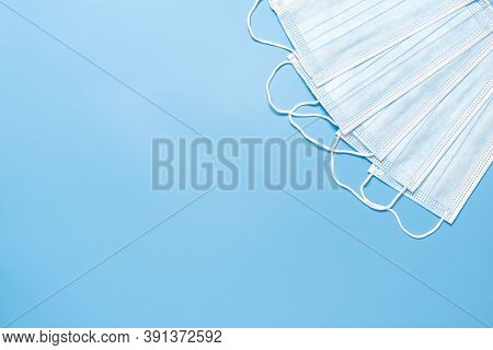 Blue Antiviral Medical Face Masks On Blue Background With Copy Space. Surgical Protective Masks With